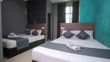 A hotel room with two beds, each with a wooden headboard, grey bedding, and a grey throw blanket.