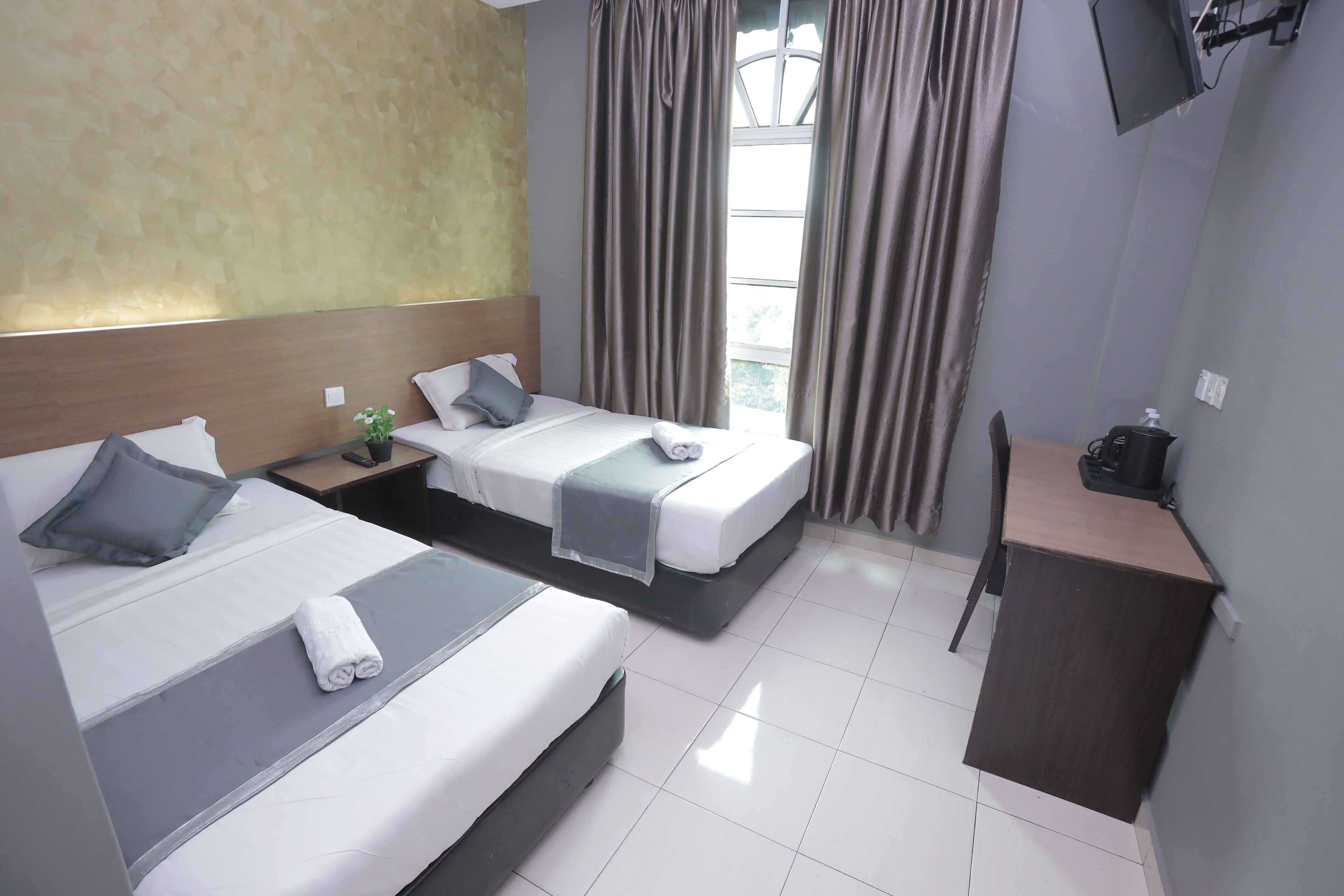 Habitación de hotel con dos camas, un escritorio y una silla.
