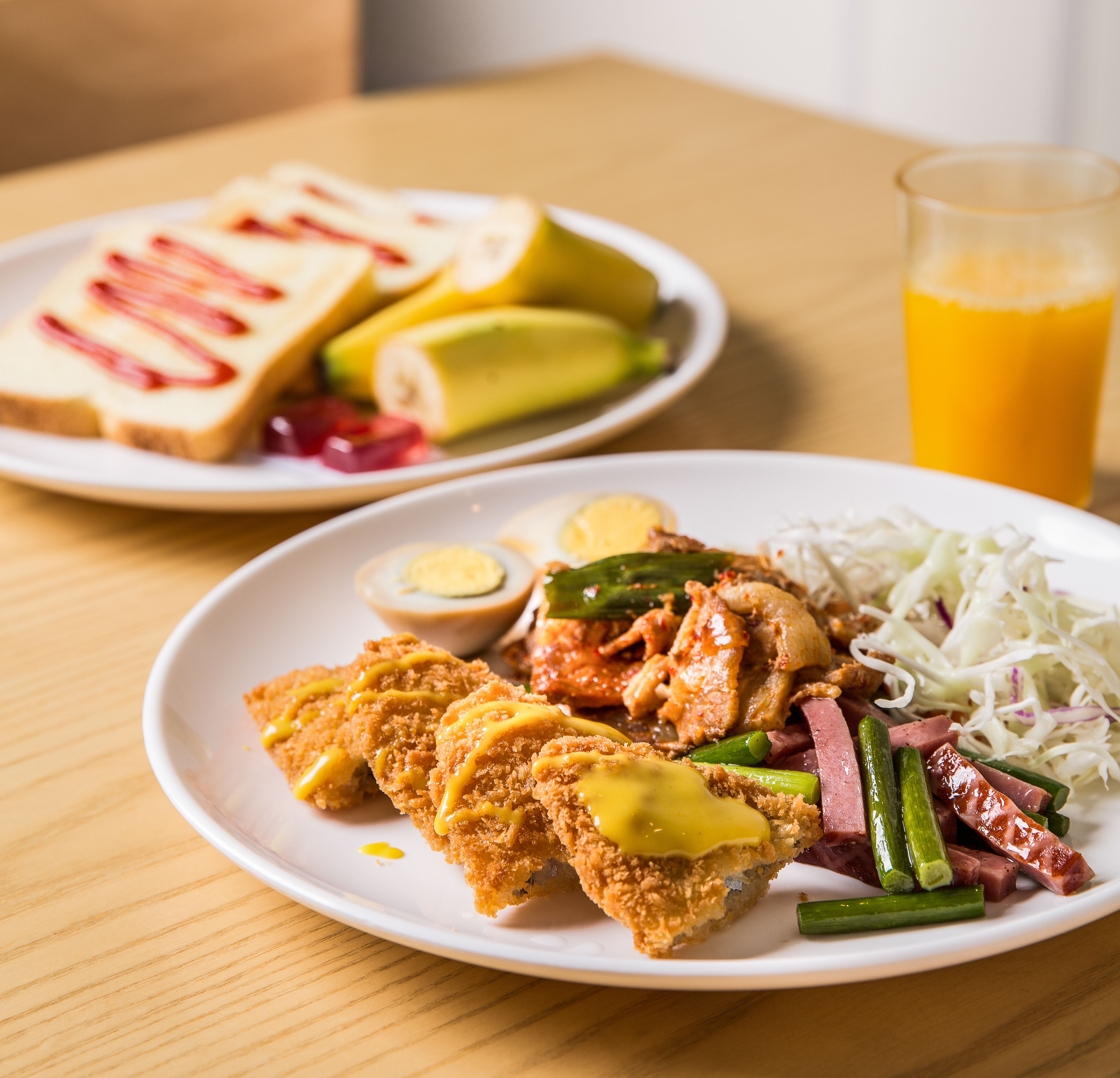 Ein Teller Essen mit Brot, Avocado und einem Glas Orangensaft.