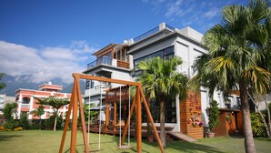 A modern building with a balcony and a swing set in the yard. - Jimei Homestay (Ji'an)
