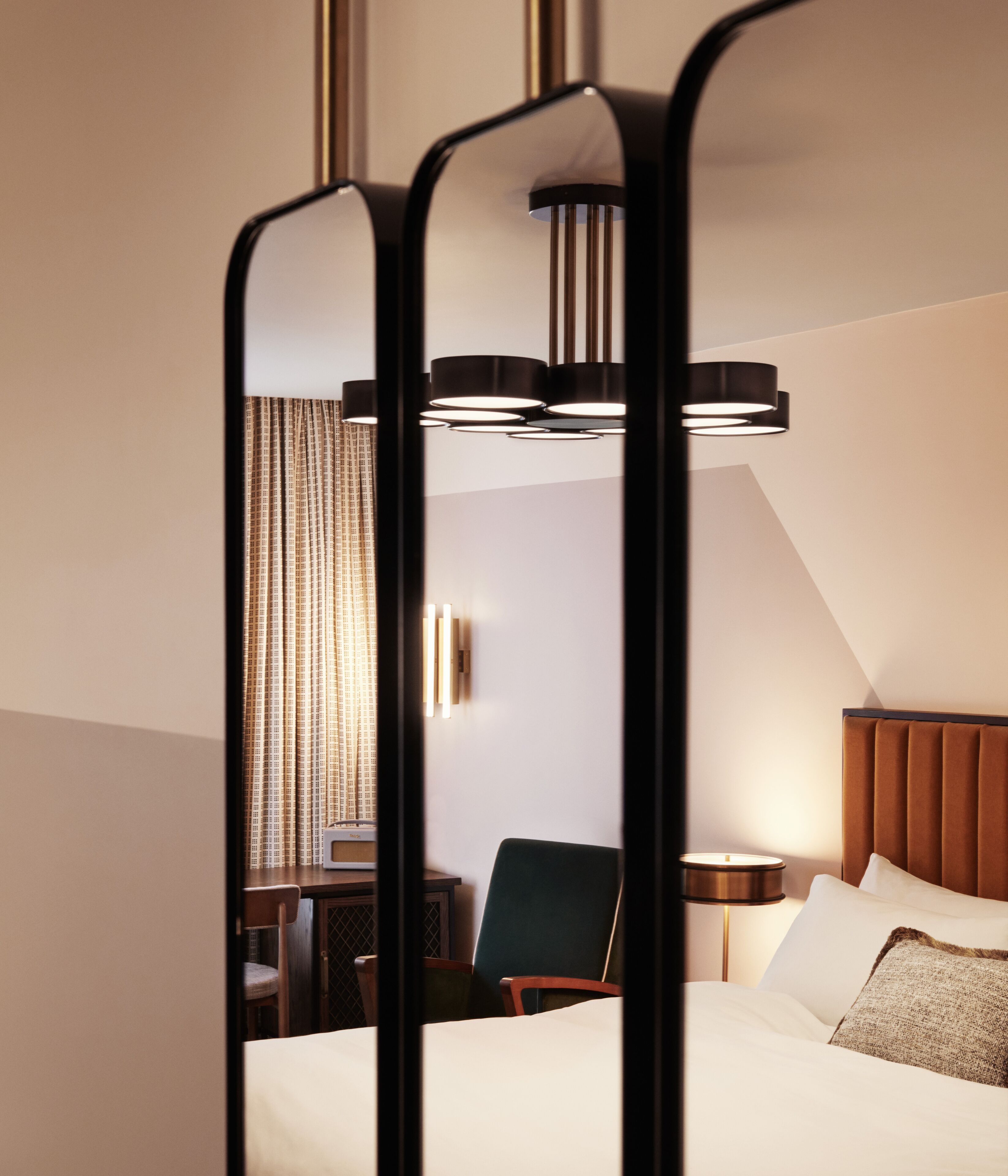Una habitación de hotel con una cama, una silla, un escritorio y un espejo.