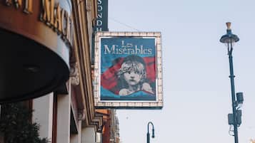A street with a sign for 'Les Misérables' and a building with a sign that reads 'HOTEL.'