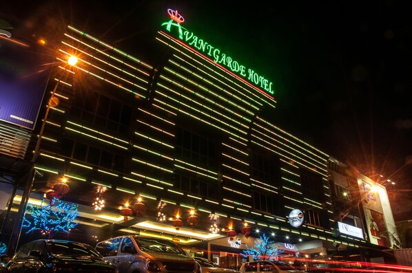 L’hôtel Van Gogh, avec sa façade moderne, est illuminé par des néons horizontaux.