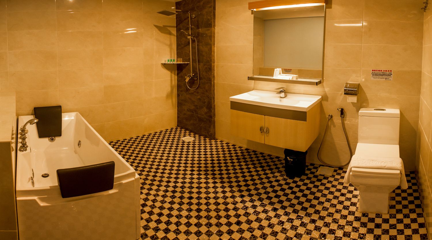 A bathroom with a checkered floor, a bathtub, a sink, and a toilet.
