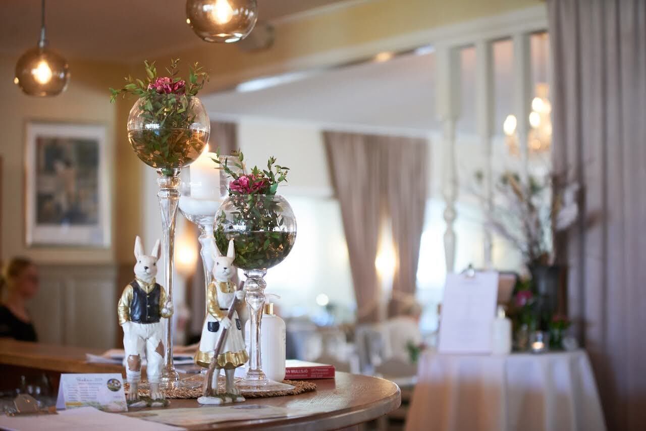 Una mesa de comedor con jarrones y figuritas de vidrio decorativas.