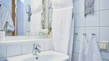 A bathroom with a white sink, a mirror, and a towel rack.