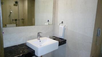 A bathroom with a white sink, a mirror, and a towel rack.