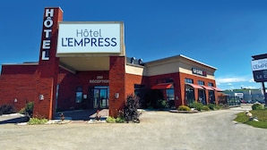 A hotel named "Hôtel L'EMPRESS" with a reception area and a sign for "La Cage". - Hôtel L'Empress (Rimouski)