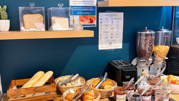 Un buffet de petit-déjeuner comprenant du pain, des viennoiseries et diverses garnitures.