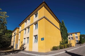 A yellow multi-story building with a sign indicating 'BATHROOM C'.