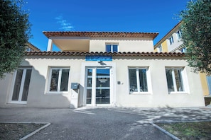 A building with a reception area, large windows, and a tiled roof.