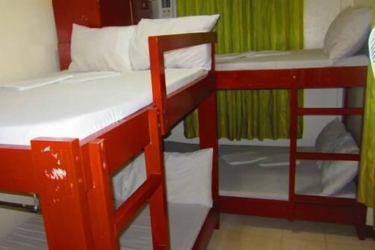 A bunk bed with a wooden frame and white bedding.