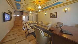 A spacious living area with a wooden staircase, a sofa set, a dining table with a laptop, and a star-patterned ceiling. - Azade Premier (Istanbul)