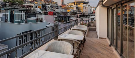 Una terraza en la azotea con mobiliario exterior y vistas al horizonte de la ciudad.