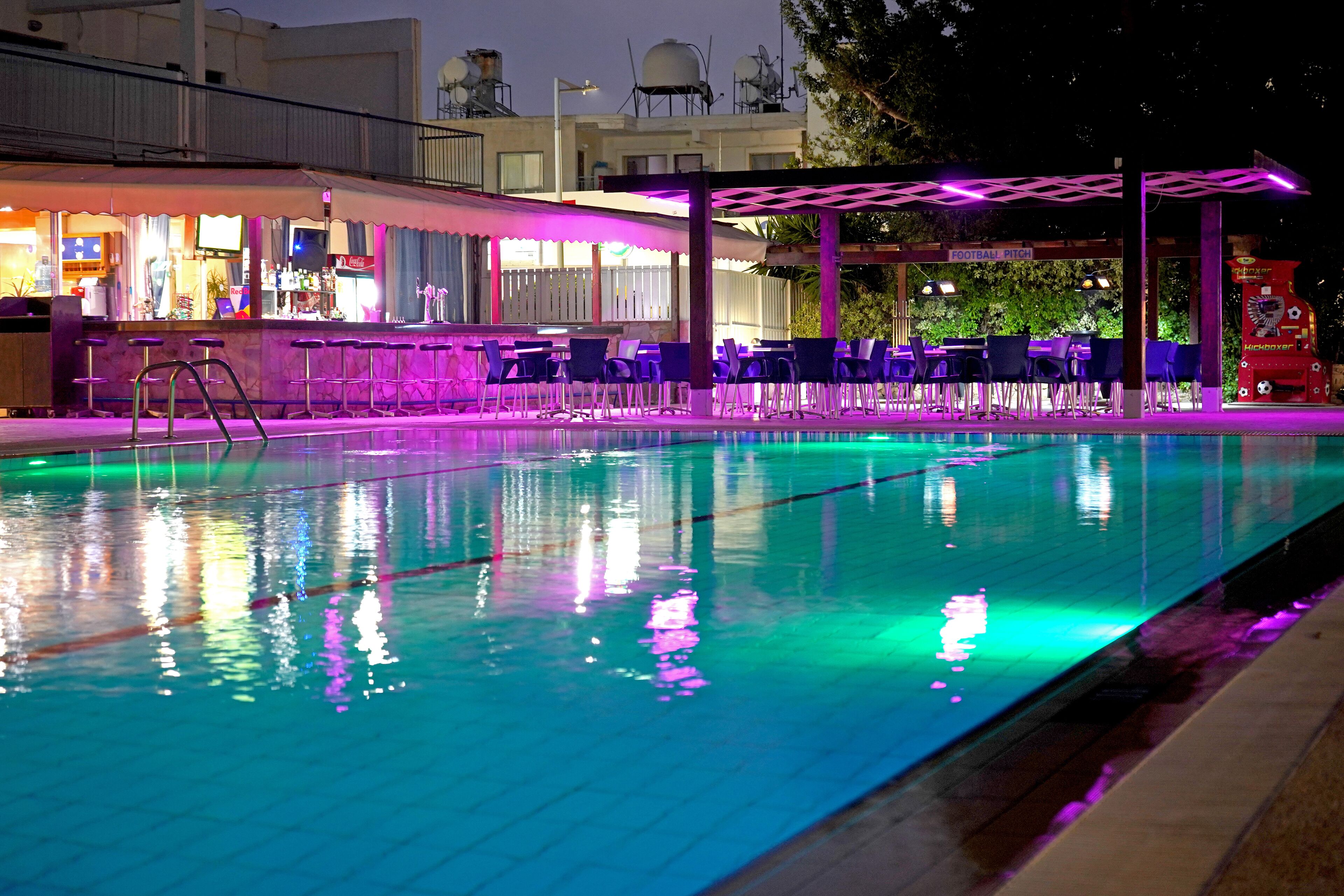 Una piscina con zona de bar y asientos al aire libre.