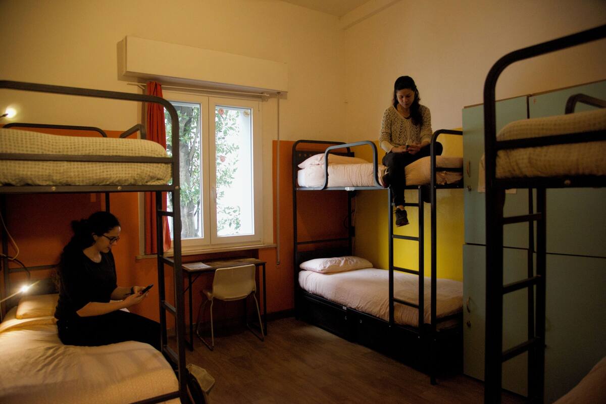 Un dormitorio con literas, un escritorio y una silla.