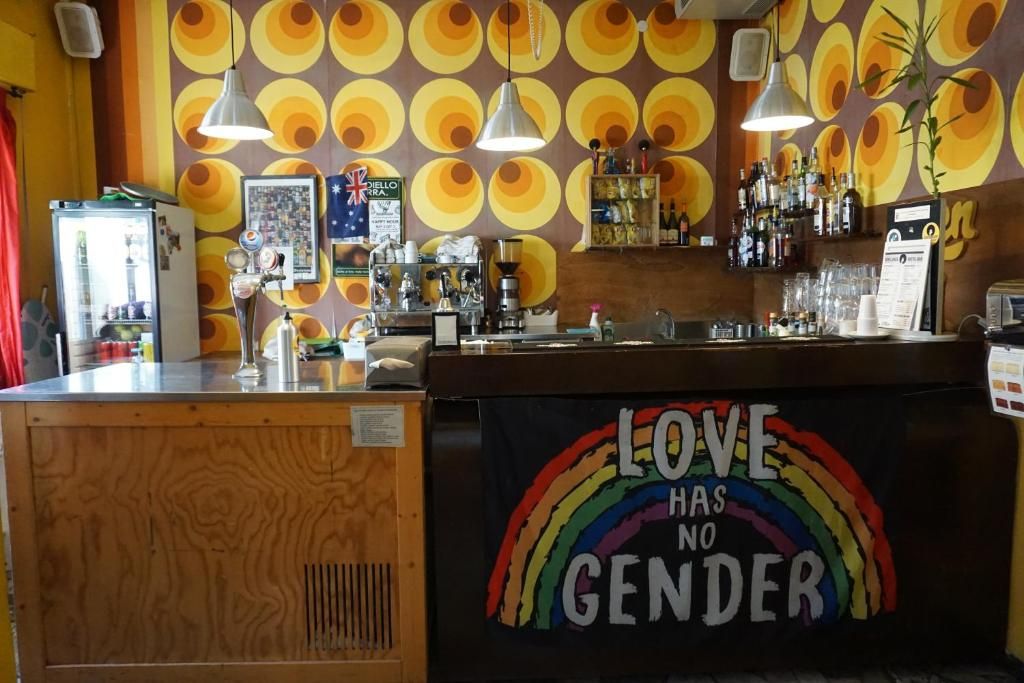 Zona de bar con mostrador, taburetes y una pared con diseños circulares.