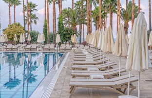 Una piscina techada, una piscina al aire libre de temporada, sombrillas