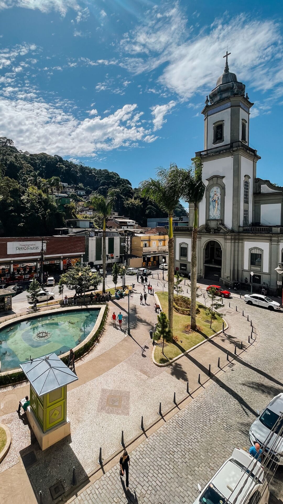 A plaza with a fountain, a church, and surrounding buildings.