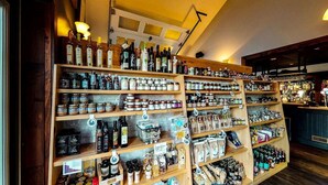 A well-stocked liquor and food store with shelves of various bottles and jars. - Auberge du Marchand (Maria)
