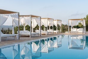 A poolside area with white canopies and lounge chairs.
