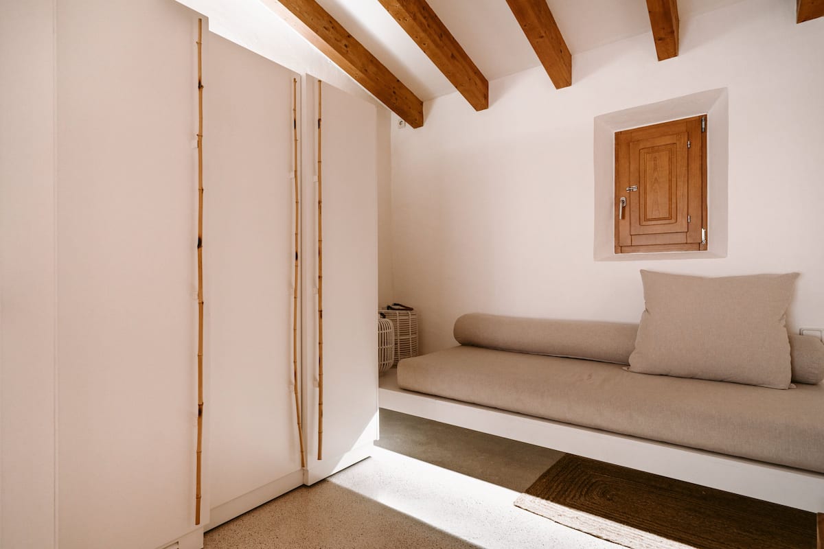 Una habitación con un sofá, un armario y una puerta corredera.