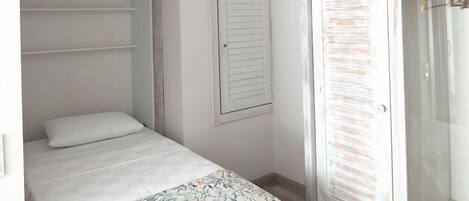 A bedroom with a bed, a wardrobe, and a door.