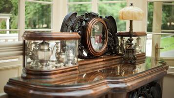 A wooden table with a mirror, a lamp, and glass objects.