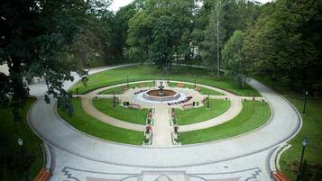 A circular park with a central fountain, benches, and a paved walkway.