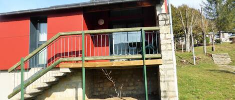 Un edificio rojo con una escalera de madera que lleva a un balcón.