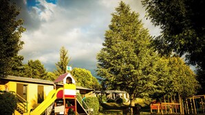 A yellow building with a red roof, a slide, and a staircase. - Domaine Aigoual Cévennes (Meyrueis)