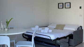 Ein kleines Zimmer mit einem Bett, einem kleinen Tisch und zwei Stühlen.