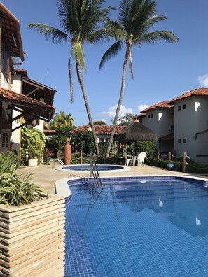 Een buitenzwembad, ligstoelen bij het zwembad