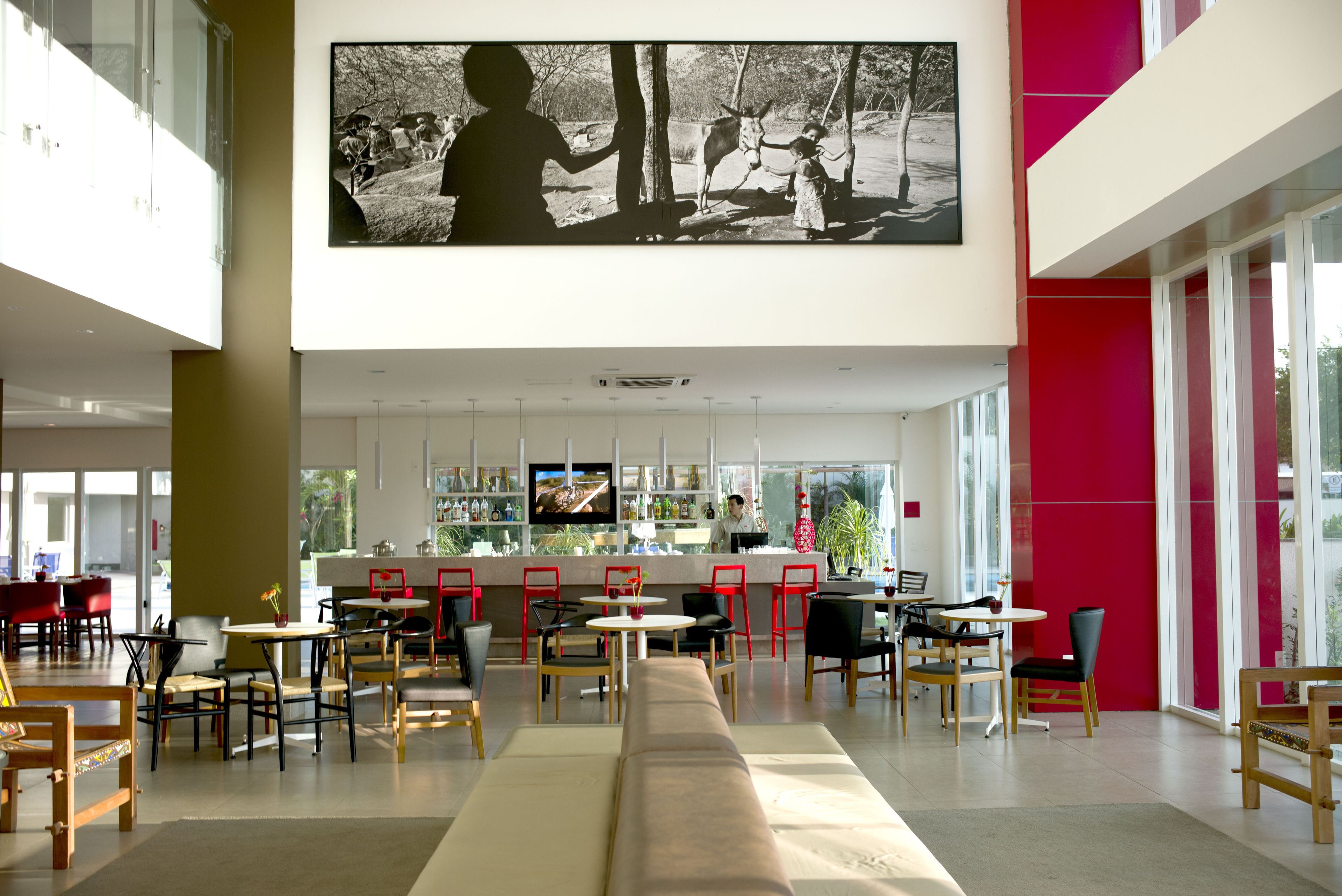 A modern restaurant with a bar area, seating arrangements, and a large black-and-white photo on the wall.