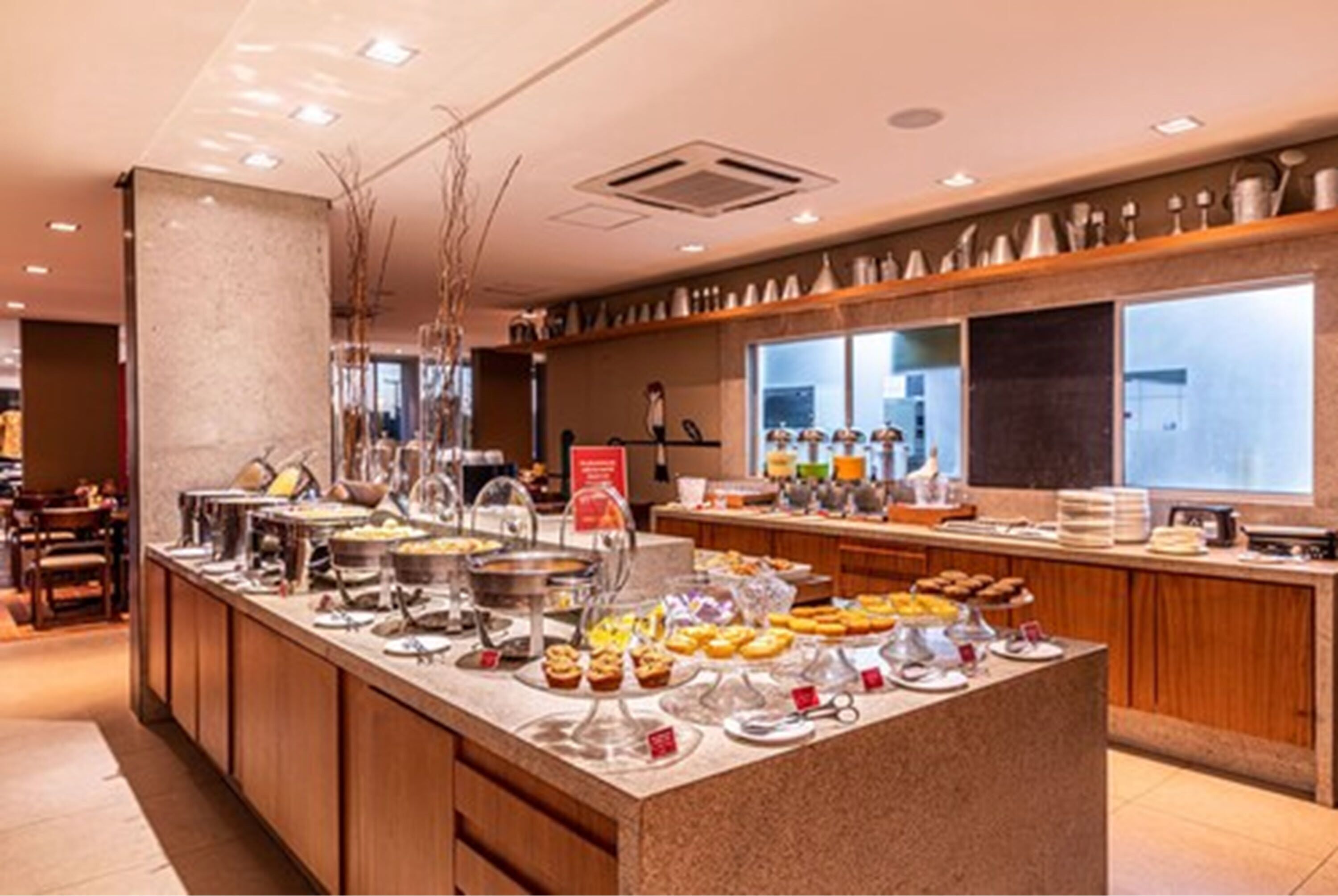 Buffet com diversos alimentos e um espaço para café.