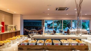 Un espace buffet proposant une variété de plats et offrant une vue sur l’extérieur.