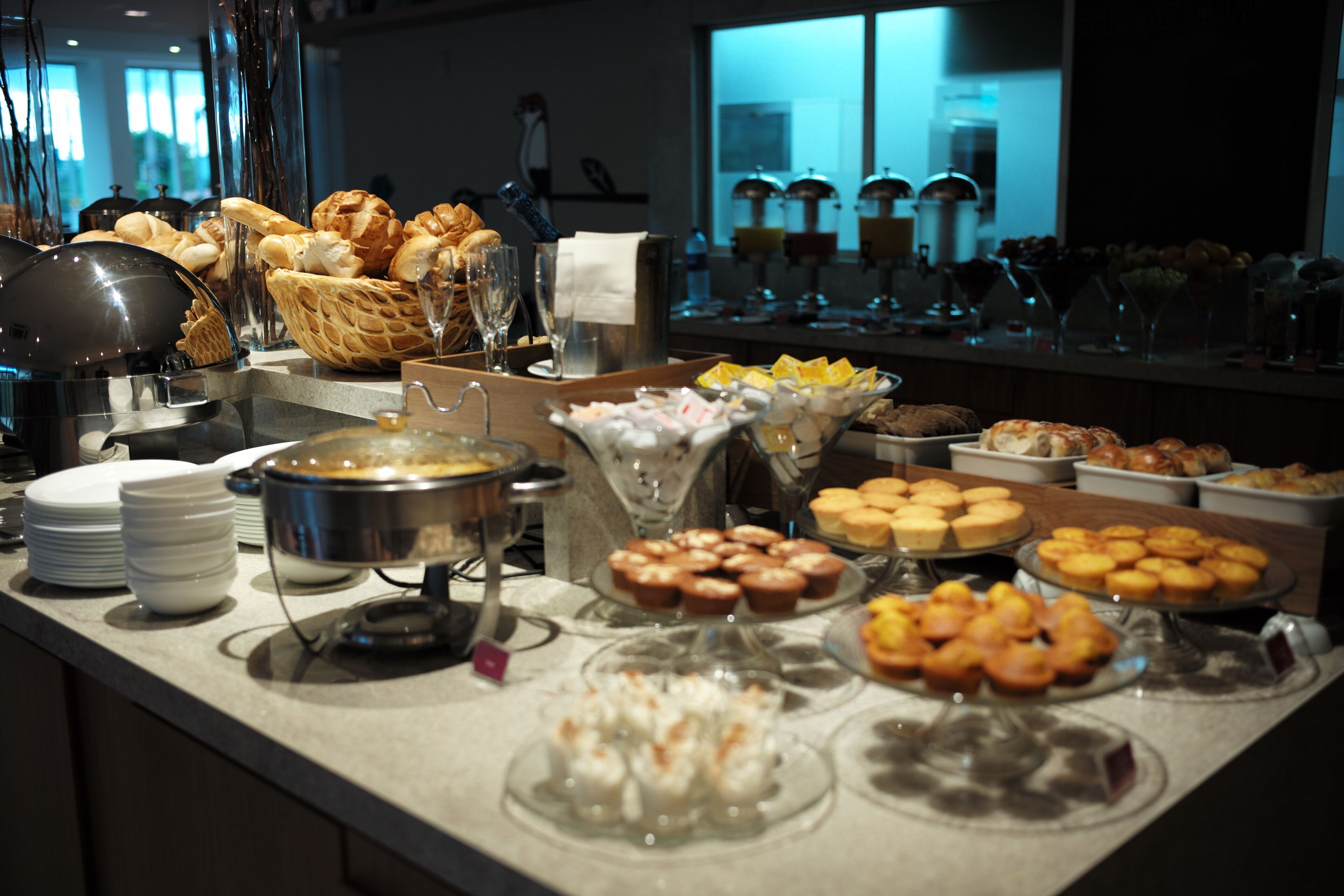 A buffet with various baked goods and beverages.