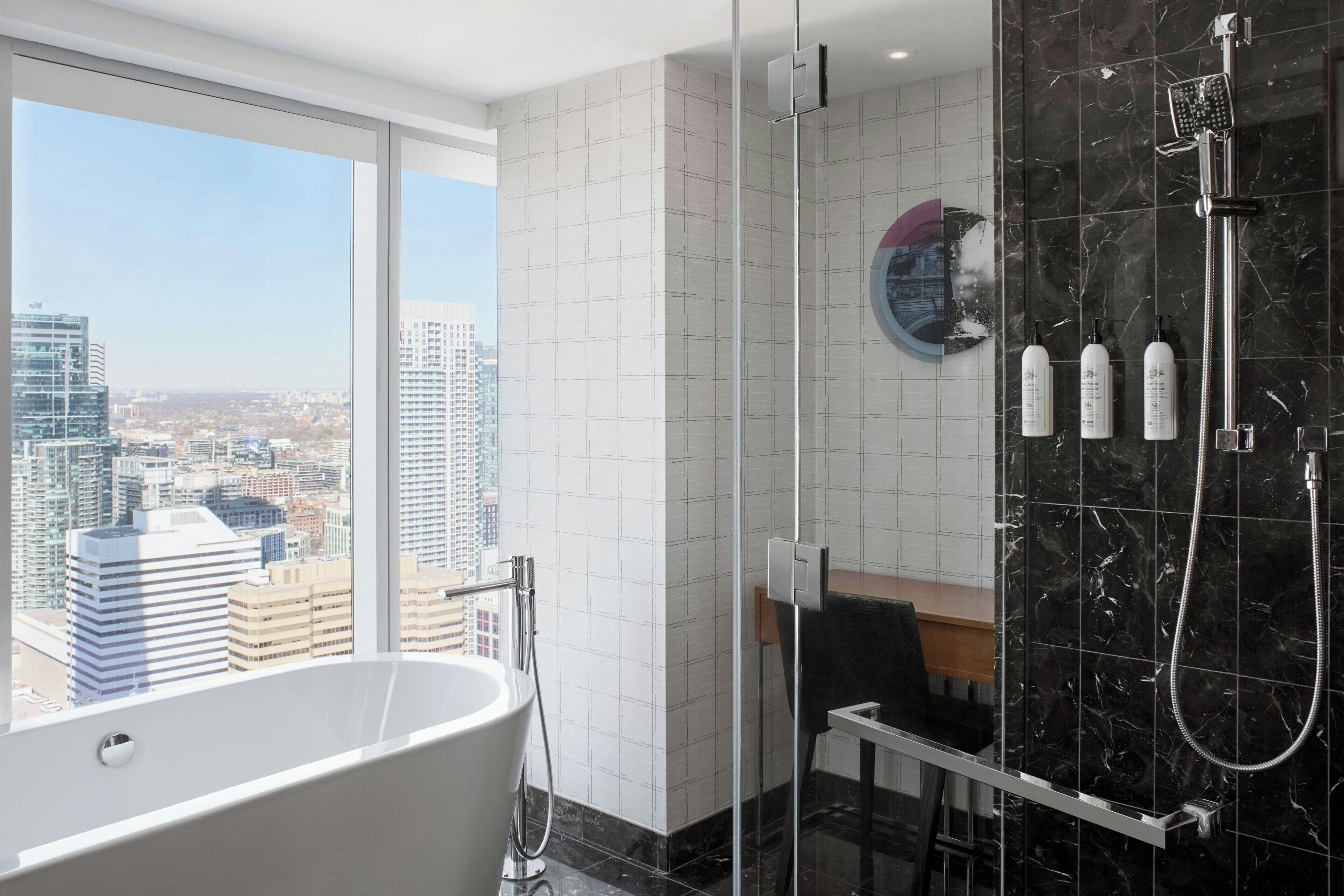 Un baño moderno con bañera, ducha y vistas a la ciudad.