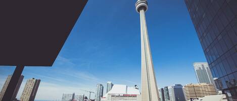 Un immeuble de grande hauteur, avec une tour imposante, le Rogers Centre et le centre de congrès de Toronto en arrière-plan.