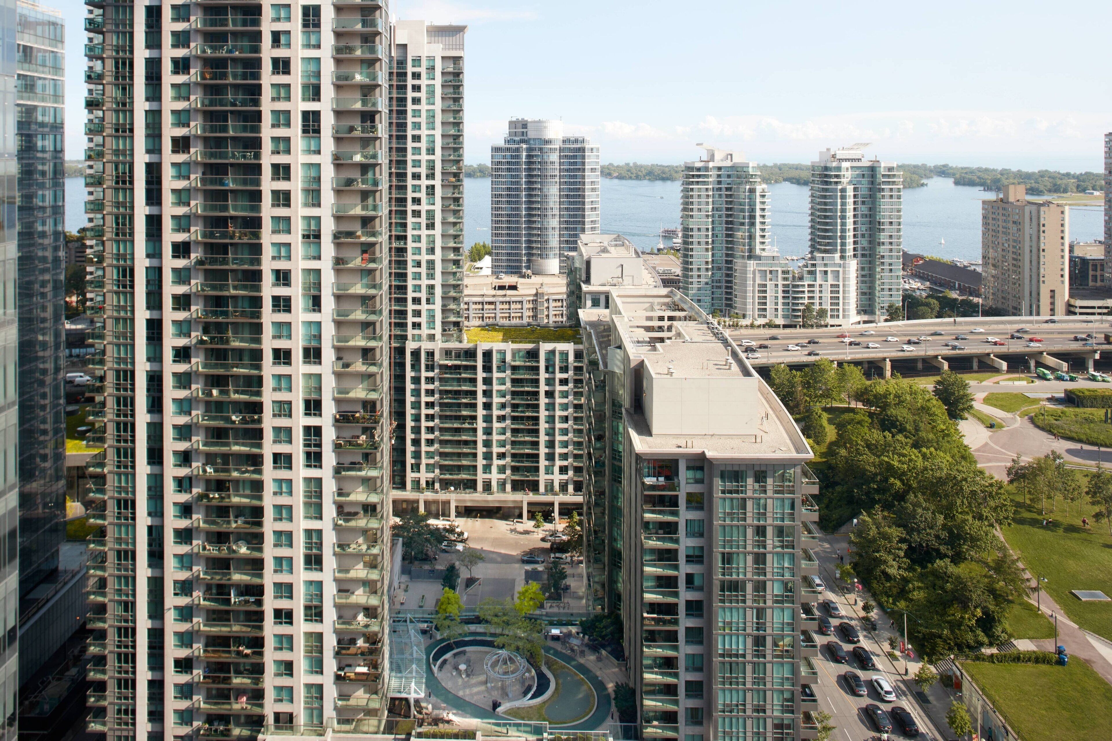 A high-rise building with multiple floors, large windows, and a central courtyard with a circular design.