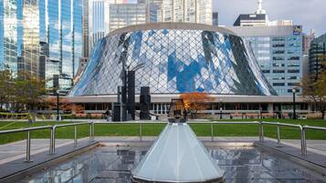 A modern building with a glass facade and a unique conical roof structure.