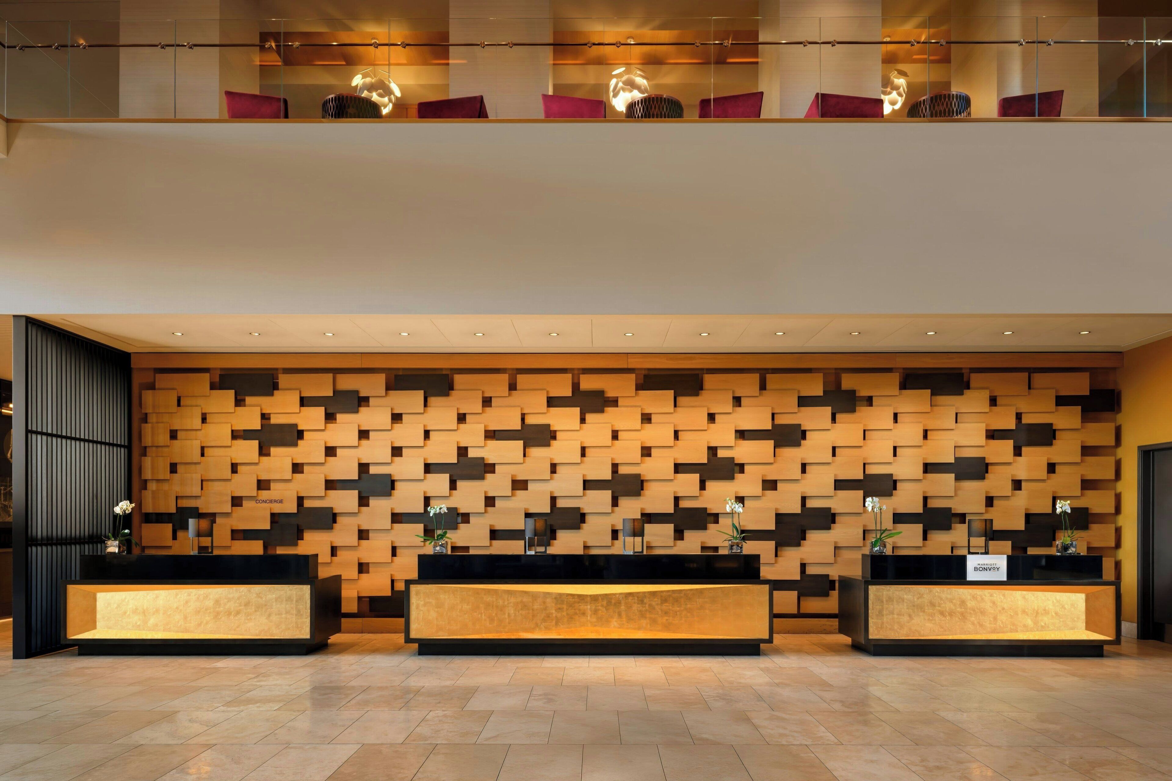 A reception area with a modern design, featuring a wooden wall pattern and a reception desk with a nameplate.