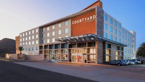 Un hotel Courtyard by Marriott de diseño moderno, con una entrada amplia y un área de estacionamiento.