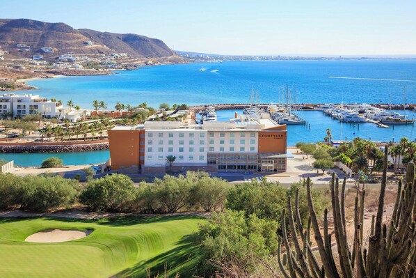 A coastal hotel with a marina, golf course, and desert landscape.