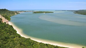 A coastal landscape with a sandy beach and a large body of water. - Gungaporanga Hotel (Barra de São Miguel)