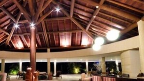 A spacious outdoor area with a wooden ceiling and a bar area. - Gungaporanga Hotel (Barra de São Miguel)
