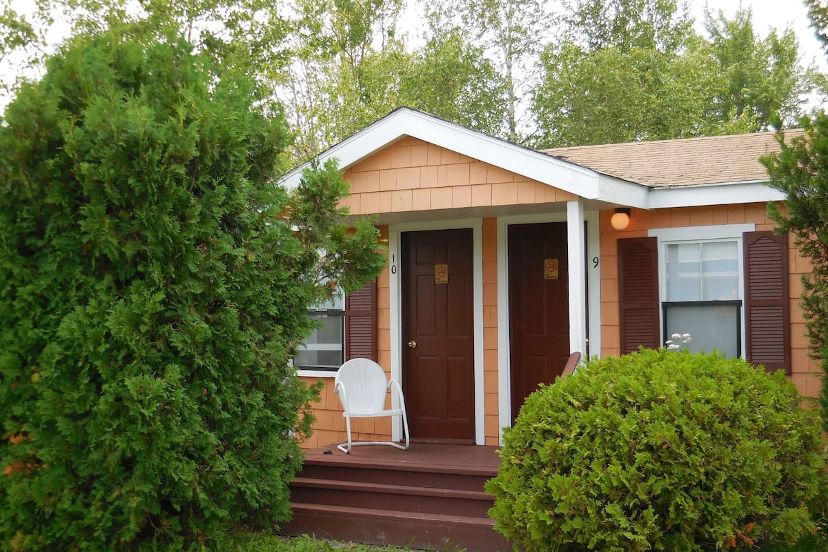 A single-story house with a front porch, a door, and a window.