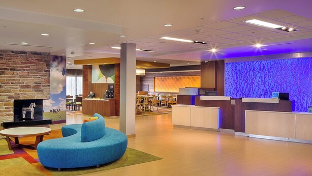 A modern lobby with a reception desk, seating area, and a fireplace. - Fairfield Inn & Suites Monaca (Monaca)