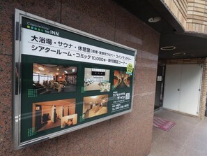 Un cartel de hotel con texto en japonés, que indica servicios como un spa, restaurante y gimnasio.