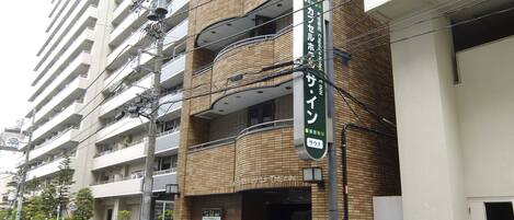 A multi-story building with a sign indicating a business establishment.